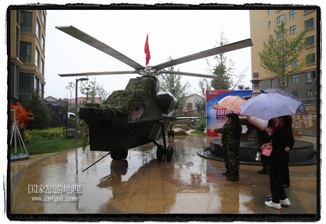 小區(qū)突然出現(xiàn)“飛機(jī)坦克”，其中殲15艦載戰(zhàn)斗機(jī)一架、99式主戰(zhàn)坦克一輛、武直-10武裝直升機(jī)一架，吸引了眾多市民雨中圍觀、合影。